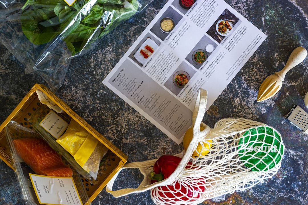 Ingredienser og opskrift fra en måltidskasse arrangeret på et mørkt bord.